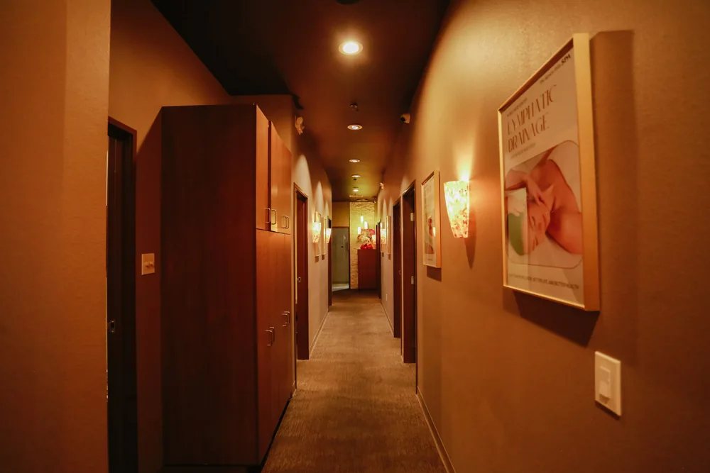Warm, dimly lit spa hallway with wall sconces